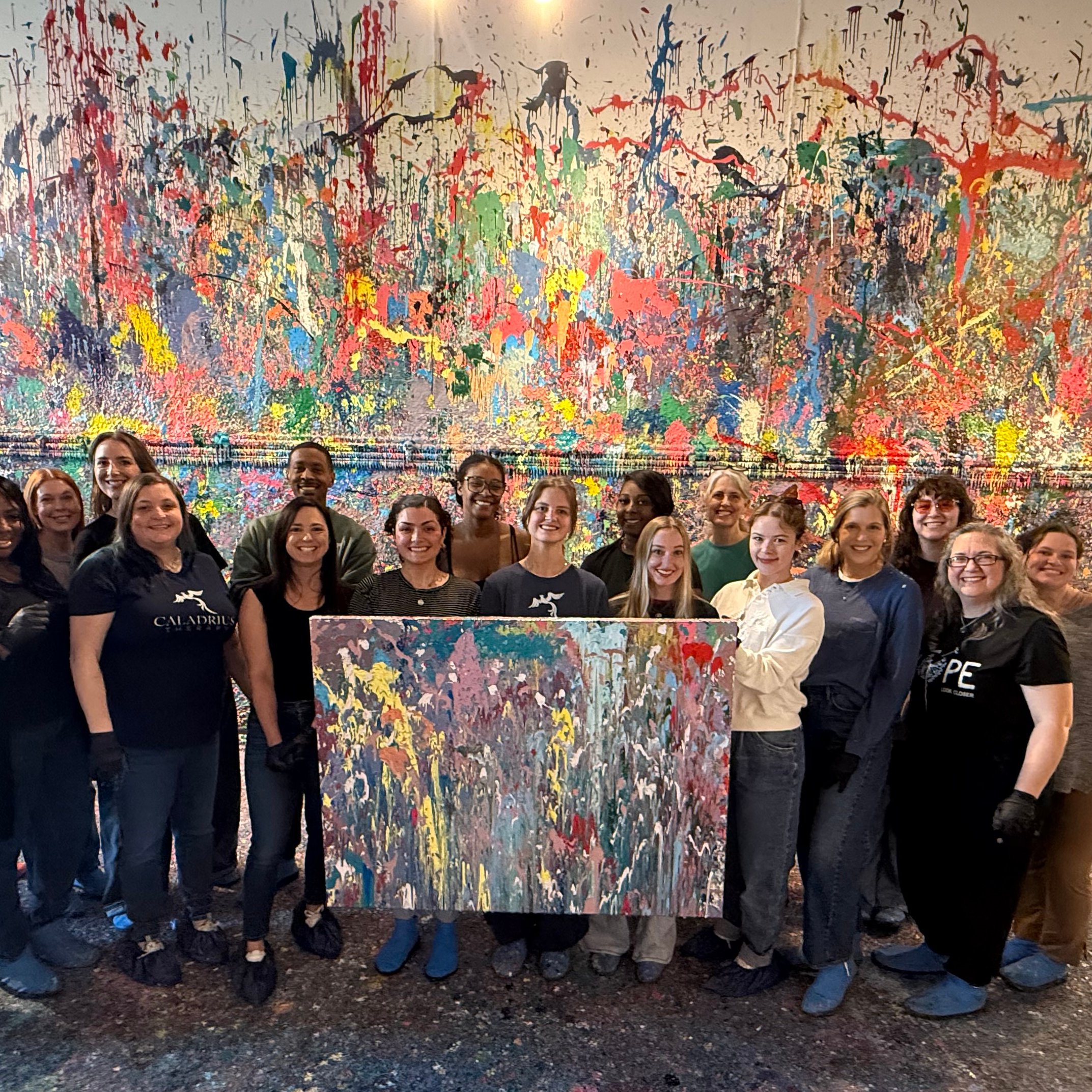 The Caladrius Therapy team holding a paint canvas at a team event